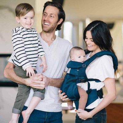 maman avec porte bébé physiologique bleu marine face porteur