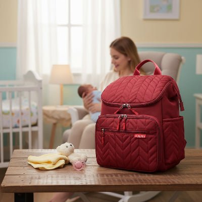 maman avec sac a dos sac a langer rouge