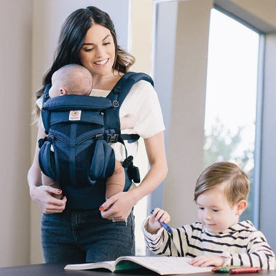 maman en famille avec porte bébé physiologique bleu marine