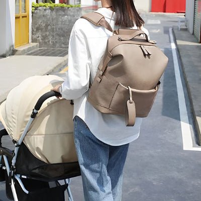 maman et poussette portant sac a dos a langer marron