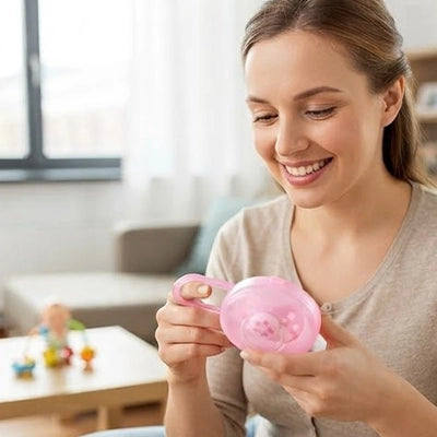 maman souriant avec boite a tetine bebe Calinuvea™ rose