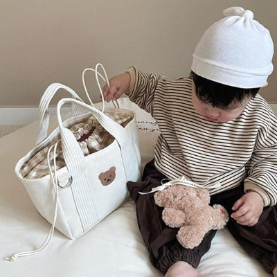 Bébé jouant et sac à langer beige