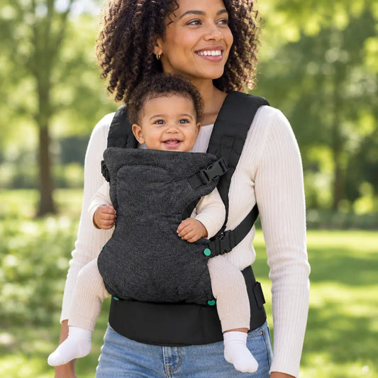 Maman souriant avec porte bebe noir ergonomique 4 positions