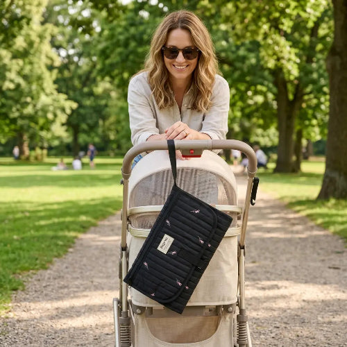 Maman souriant avec tapis de change bébé Pratinomade™ noir